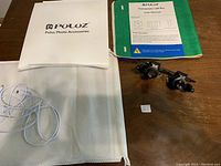 Photo of Puluz photo accessories manual, white fabric background, USB cable, and two jewellers magnifying glasses.