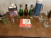 Full view of all items on table, showing bottles, thermos, glassware, shaker, napkins, and Russell Hobbs box