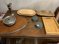 Full lot overview showing all trays, coasters, vase, and silver dish arranged on wooden table.