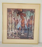 Framed forest print showing white birch trees and autumn foliage in a gold frame with cream mats.