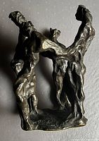 Front view of bronze sculpture showing four interlinked figures forming a square