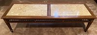 Top view of wooden coffee table showing two granite tile insets and carved apron