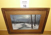 Full view of framed winter pastel painting showing snow, trees, creek, and moonlight.