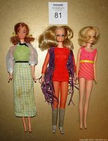 Front view of three vintage dolls dressed in original vintage clothing, showing details of outfits and hair styles.