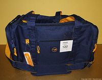Navy blue Lufthansa Airlines duffle bag with orange zipper pulls and shoulder strap, showing front side.