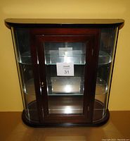 Front view of mahogany wall display cabinet showing glass door and two internal glass shelves.