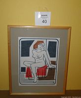 Front view of the framed artwork showing the nude multimedia drawing with mat and light wood frame.