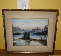 Framed pastel painting with mountain lake and pine trees scene, viewed from front showing whole artwork and frame.
