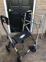 Photo showing foldable rollator walker with black padded seat, four wheels, and hand brakes.