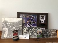 Full view of the football memorabilia showing plaque, vintage black and white photos, and small round card display