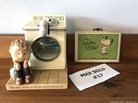 Photo showing Linus and Snoopy figurine next to vintage Snoopy plaque