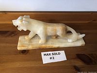 Left profile view of the marble onyx tiger statue showing overall shape and coloration.