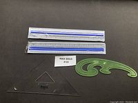 Photo showing the green French Curve, transparent set square, and two magnifying rulers.