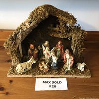 Full view of the vintage ceramic nativity set on stable showing all figurines arranged in front.