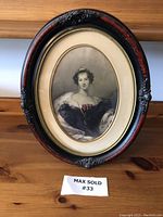 Front view of the vintage oval framed portrait showing Viscountess Beresford artwork and carved wooden frame with black and red paint.