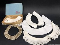 Set of 5 vintage neck collars displayed together including embroidered flower collar in box, plain white collars, eyelet design collar, and beaded collar.