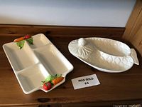 Both platters displayed on a wooden surface showing full shape and decorative features.