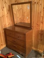 Dresser with mirror on top, showing wood finish and overall condition.
