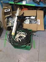 Photo of three boxes containing various electrical supplies showing black and white cables, a fluorescent light tube, an electric motor, and assorted components.