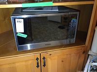 Front view of Panasonic microwave with reflective door and control panel visible.