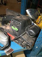 Close-up of black TMT branded belt sander covered in dust