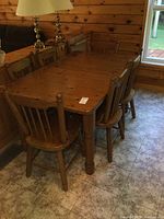 Wide view of table with six chairs in log cabin interior