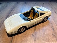 White Barbie car toy missing its windshield, showing detailed interior seats and steering wheel from an angled top perspective.