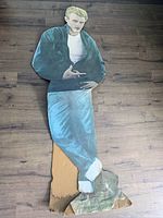 Front view of the life-size James Dean cardboard cutout showing intact image but damaged bottom and bent midsection.