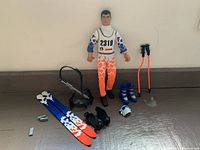 Ken doll in ski outfit and all accessories gathered on surface