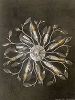 Top view showing circular base with radiating chrome arms and glass bulb covers shaped like flower buds and leaves.