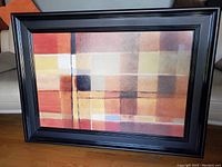 Photo of abstract framed print on the floor showing colors and design