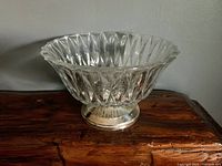 Side view of the vintage clear glass dish showing its shape and silver base.