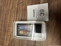 Front view of the sealed Apple iPod Nano packaging showing colorful touchscreen interface icons.