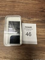 Front view of brand new Apple iPod Nano in clear plastic packaging showing device screen and click wheel