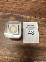 Front view of the packaged Apple iPod Shuffle showing the circular control pad.