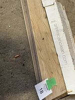 Photo showing stacked tile boxes with visible wood grain texture giving hardwood appearance.