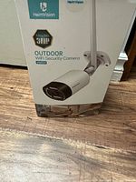 Box of HeimVision HM311 3MP Ultra HD Outdoor WiFi Security Camera showing product image and branding.