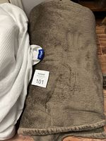 Brown fleece blanket folded showing its plush texture and brown color with Casal brand tag visible.