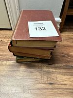 Stack of five antique books showing edges and top book's spine with wear