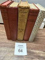 Image of five antique hardcover books standing upright, showing titles and condition.