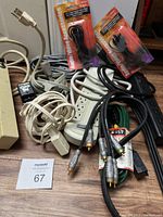Lot of cables showing various extension cords, power bars, A/V cables, and packaged new accessory cables.