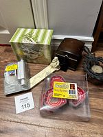 Lot items arranged showing small wooden box, decorative ceramic piece, tea light candles, recipe card box, and packaged solid door stop