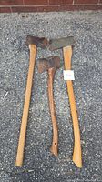 Three weathered vintage axes laid on gravel surface, showing overall condition and size comparison