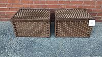 Photo of two woven storage chests side-by-side against brick wall, showing front view with label 31 on one chest.