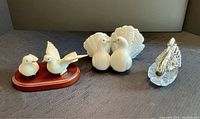 Photo showing all four bird figurines including Lladro doves, Mikasa doves on wood stand, and glass & metal swan