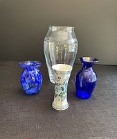 Front view of the four vases on dark fabric background.