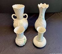 Front and side view of all four Belleek porcelain vases showing various shapes, handles, and shamrock decorations.