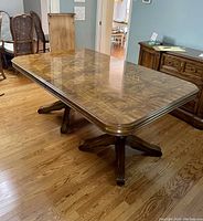 Three-quarter view of dining table top and dual pedestals on hardwood floor
