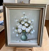 Front view of framed oil painting showing white flowers in a green vase with signature 'Danny'