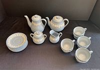 Top view of full tea and coffee service arranged on black background